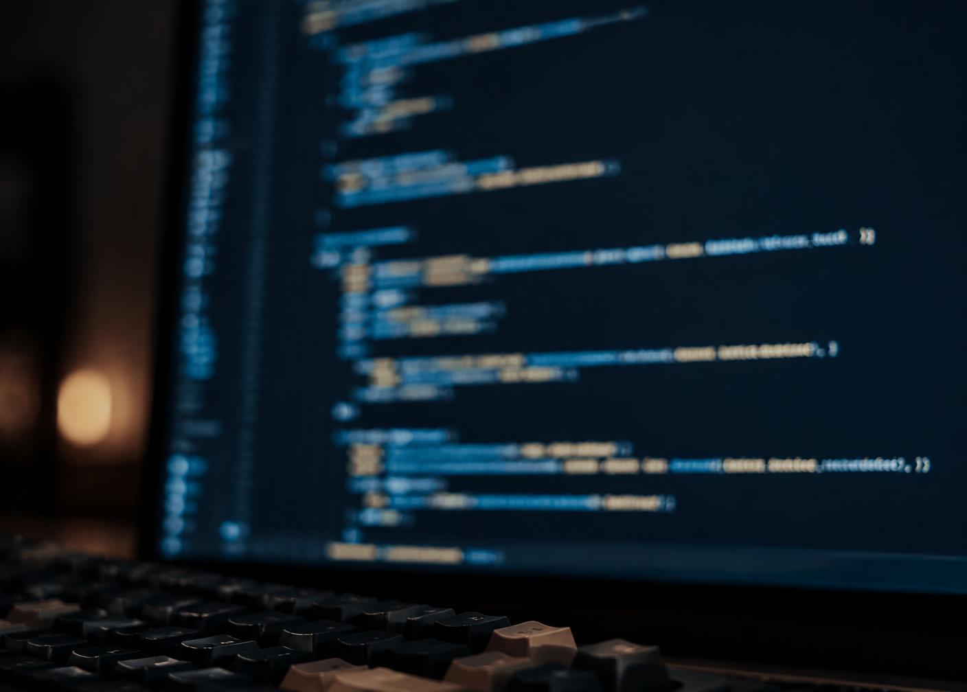 Code editor with syntax-highlighted source code on a monitor in a dim room
